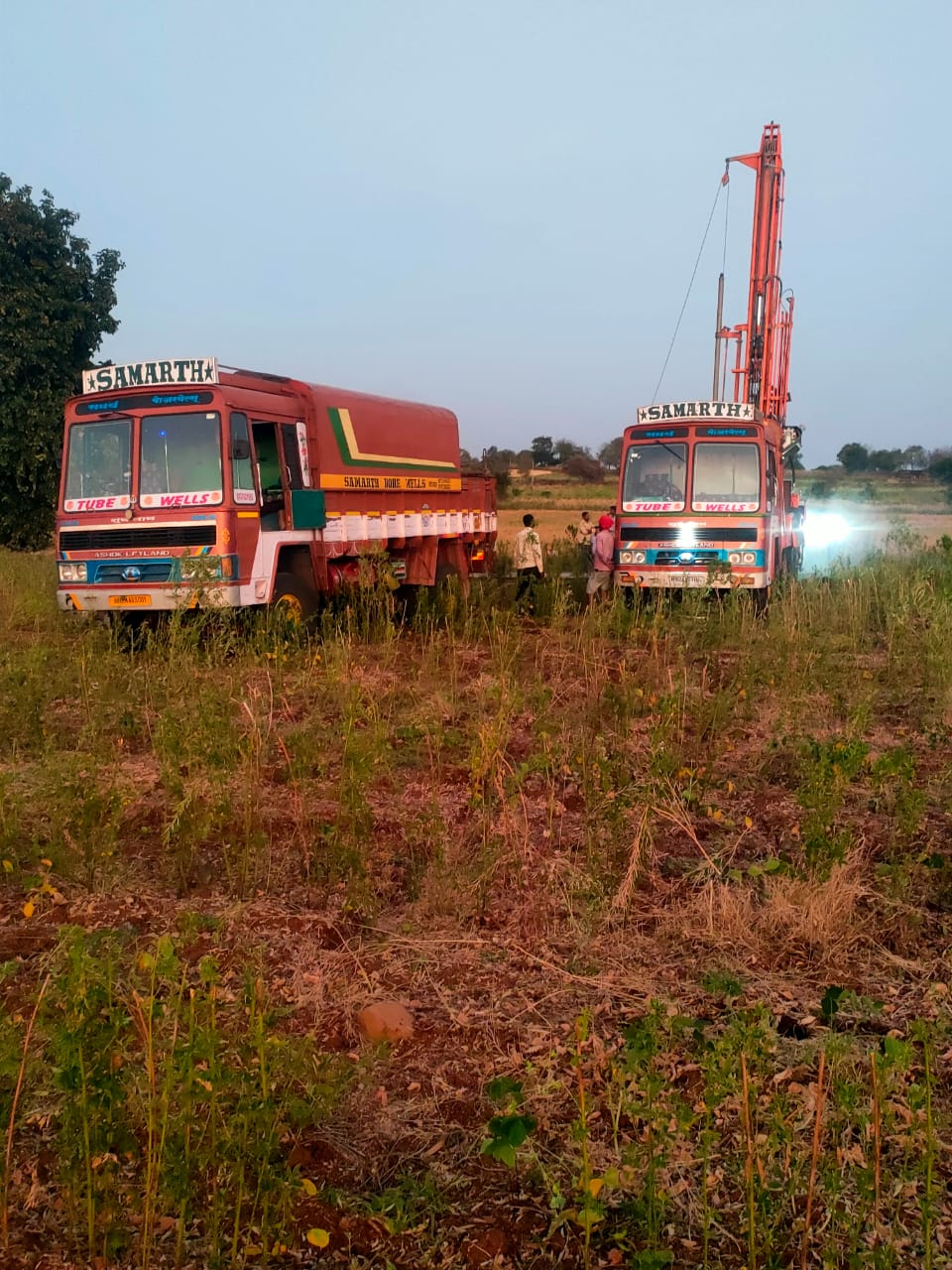 RK Borewells drilling rigs at work in an Andhra Pradesh field at dusk